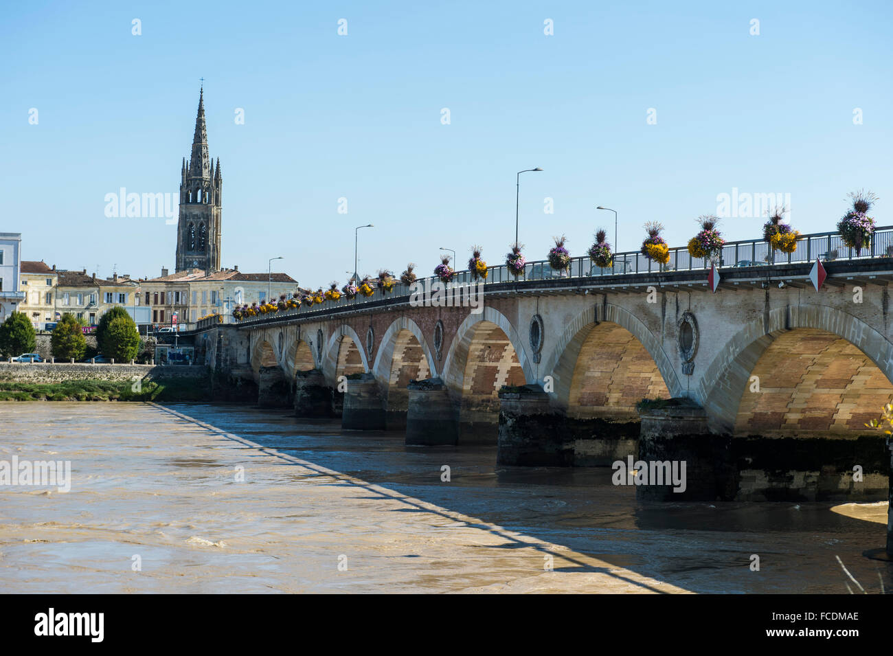 Arch bridge over the Dordogne river, at the back the church Eglise Saint-Jean Baptiste, Libourne, Département Gironde, France Stock Photo