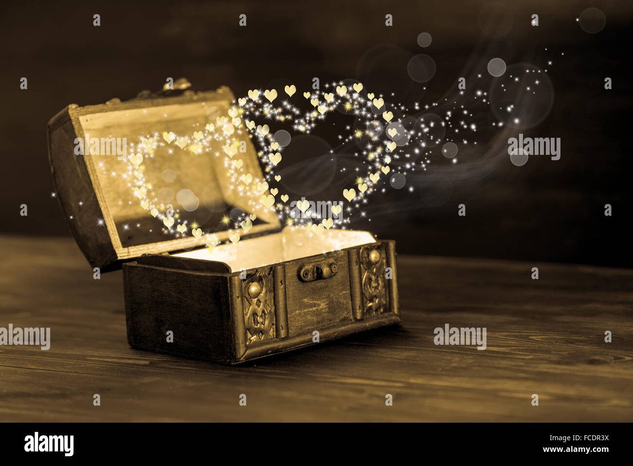 beautiful concept of vintage chest with light heart miracle on wooden