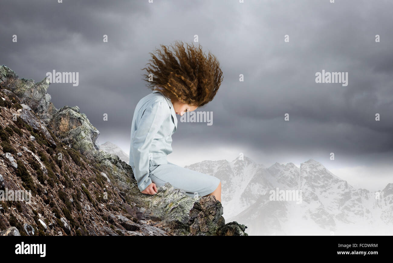 Young businesswoman with waving hair sitting on top of mountain Stock ...