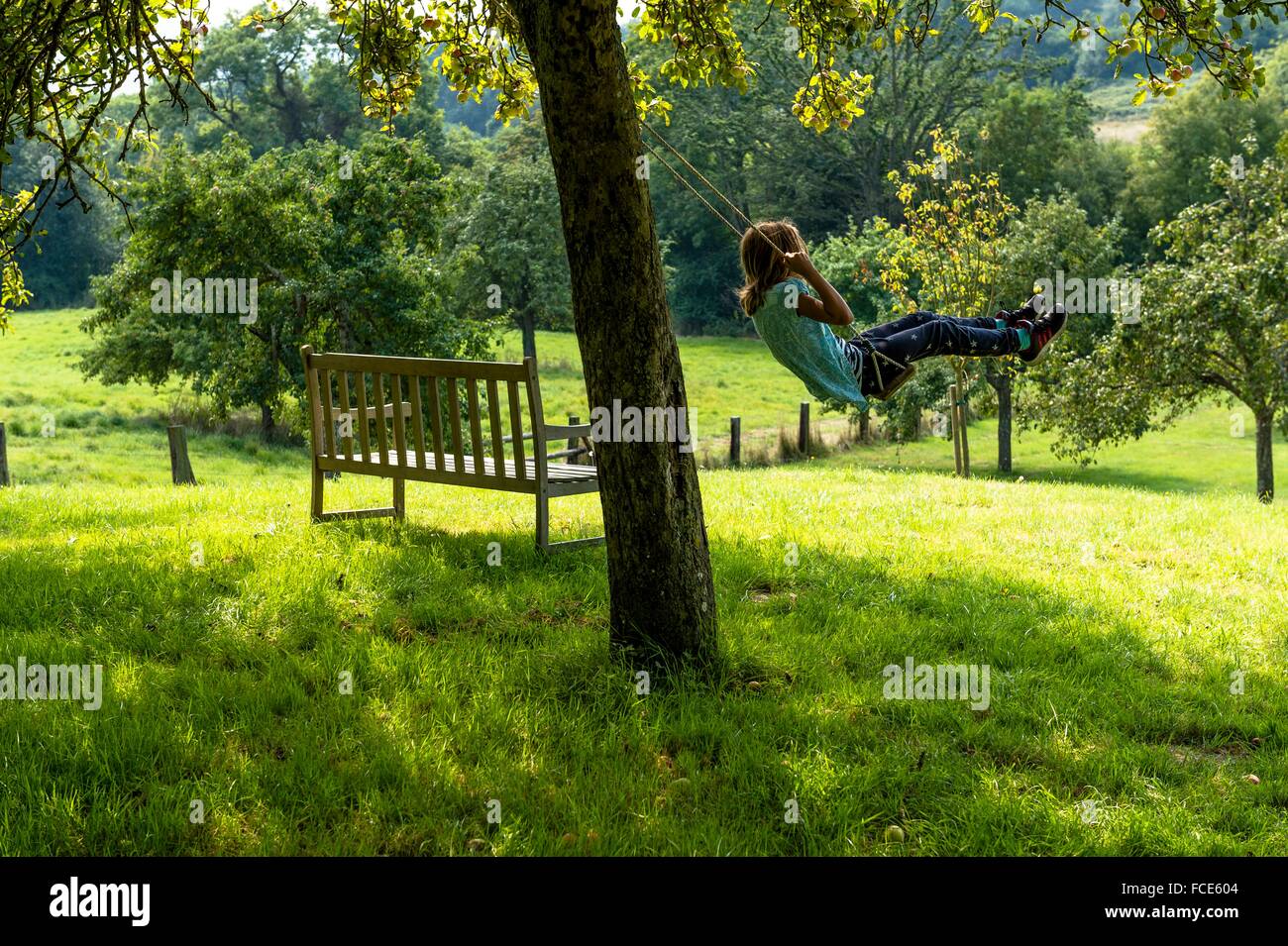France, Normandy, little girl enjoying a go on a swing in a beautiful