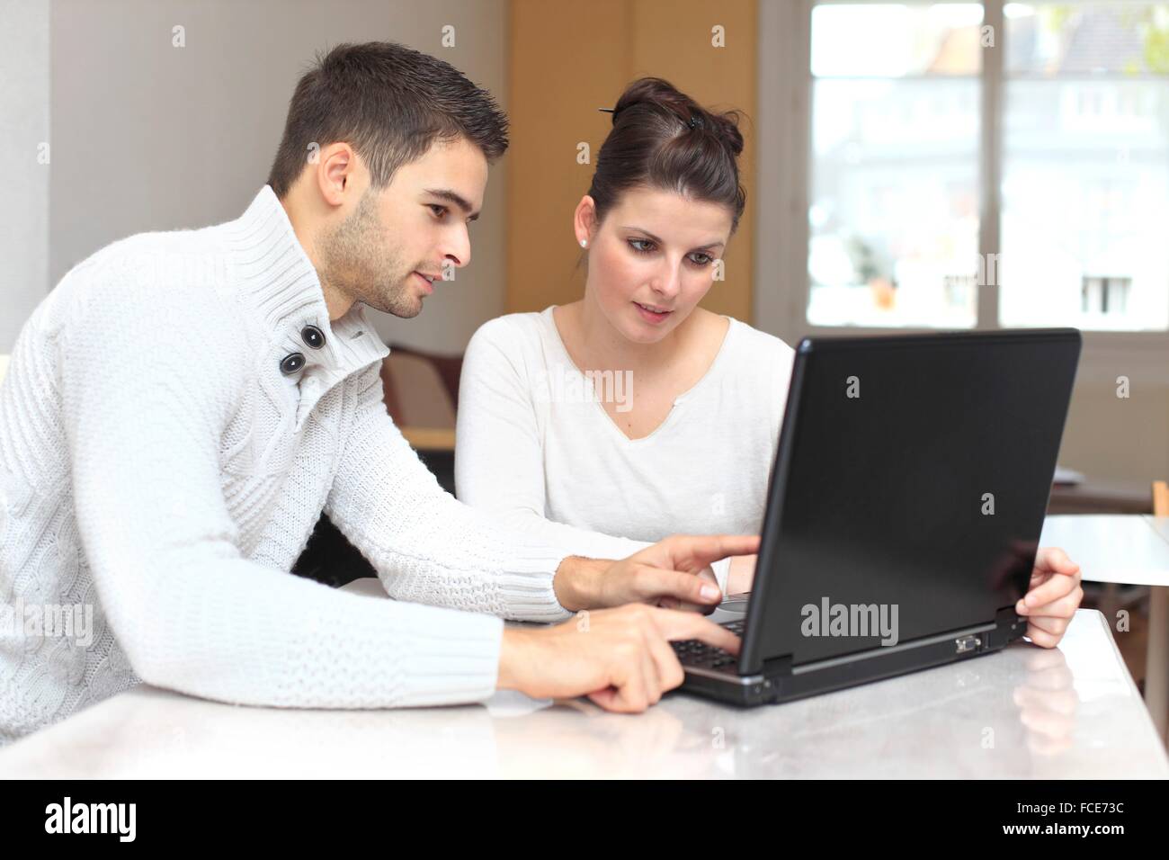 France, young couple at home using laptop Stock Photo - Alamy