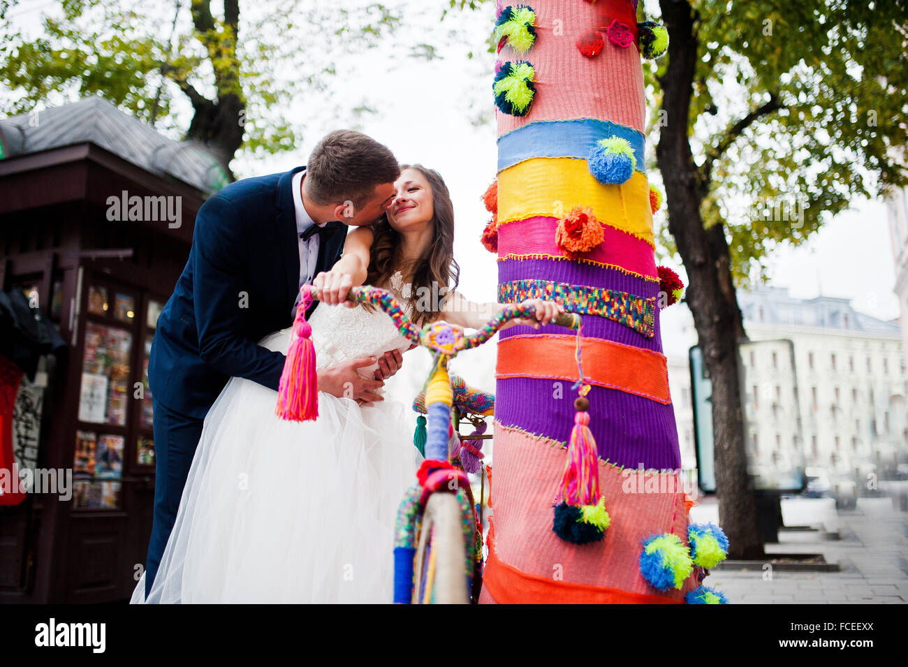 Wedding couple near colored tree with bicycle Stock Photo - Alamy