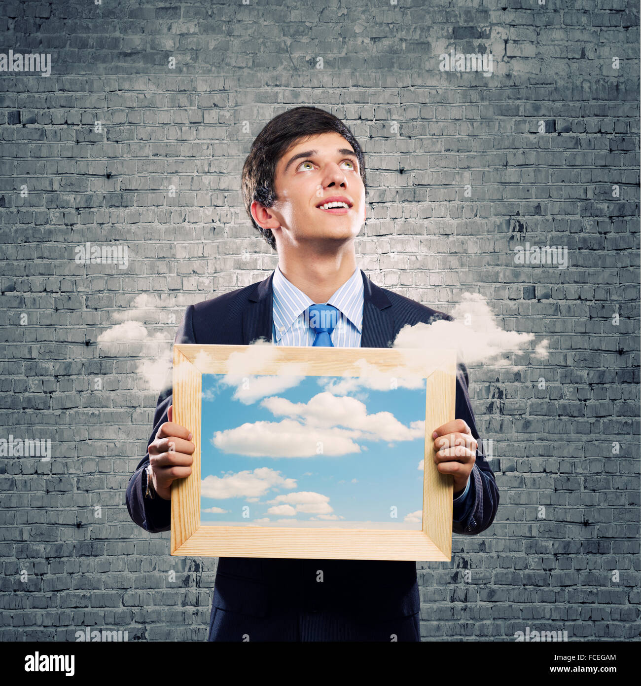 Handsome young man holding frame with pictures Stock Photo - Alamy