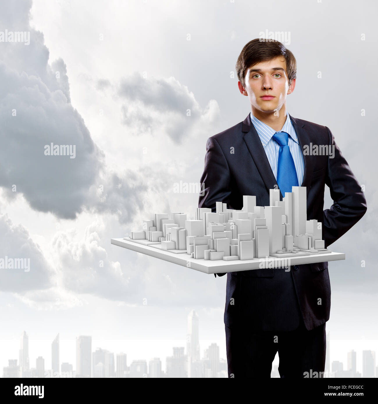 Handsome businessman holding model of modern city Stock Photo - Alamy