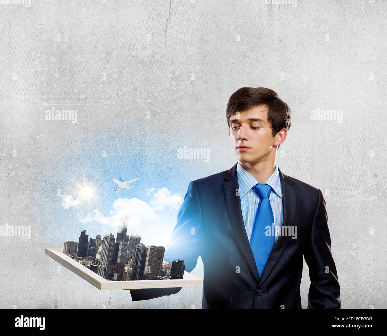 Handsome businessman holding model of modern city Stock Photo - Alamy