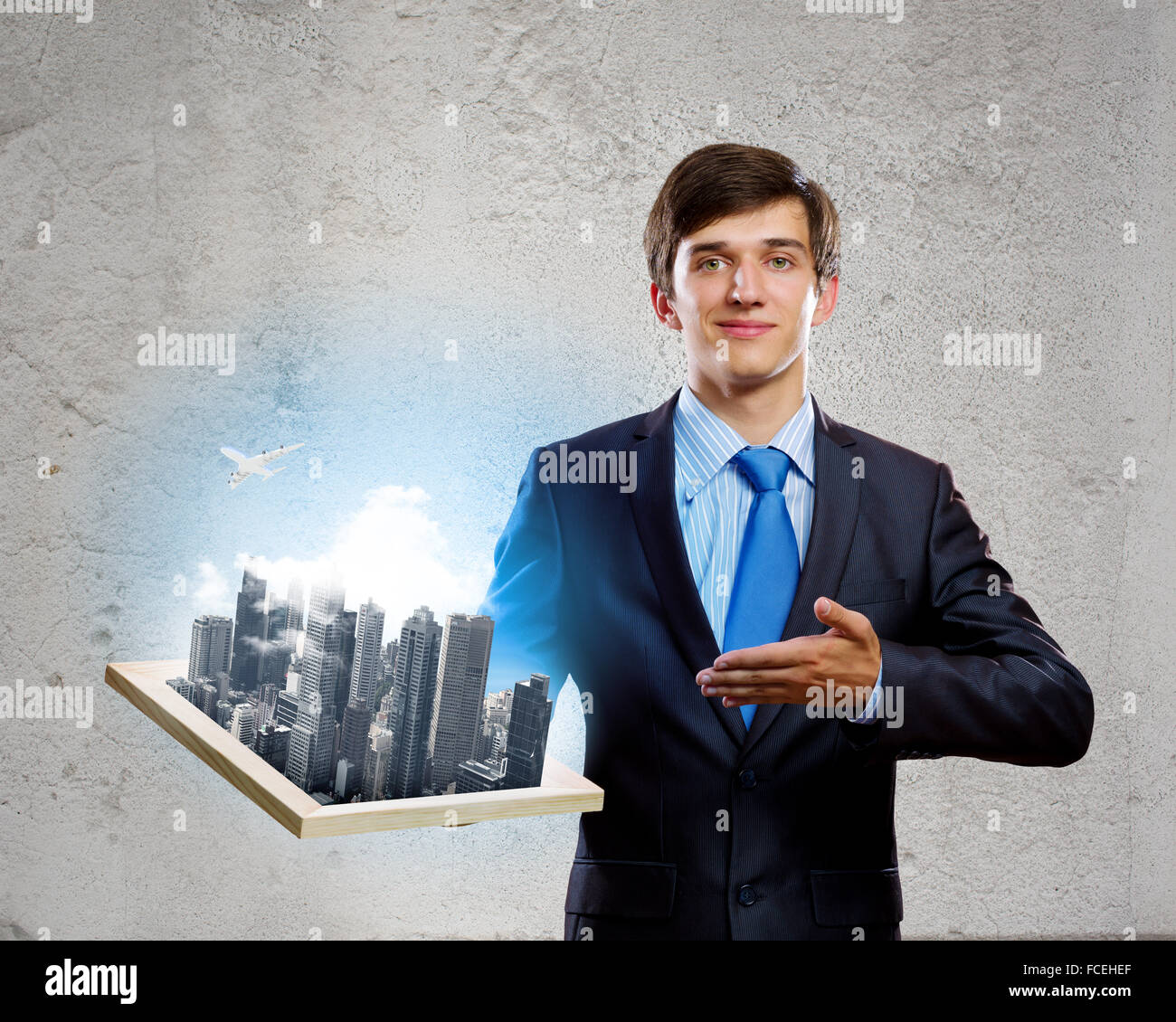 Handsome businessman holding model of modern city Stock Photo - Alamy