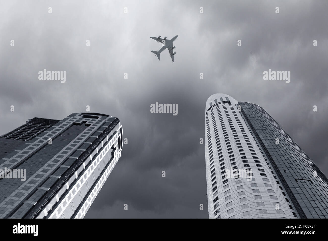 Bottom view of airplane flying above skyscrapers Stock Photo - Alamy