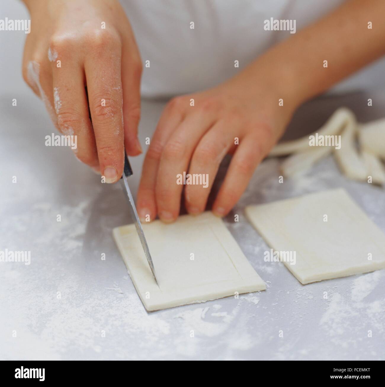 Scoring a border on pastry squares using a knife, closeup Stock Photo Alamy