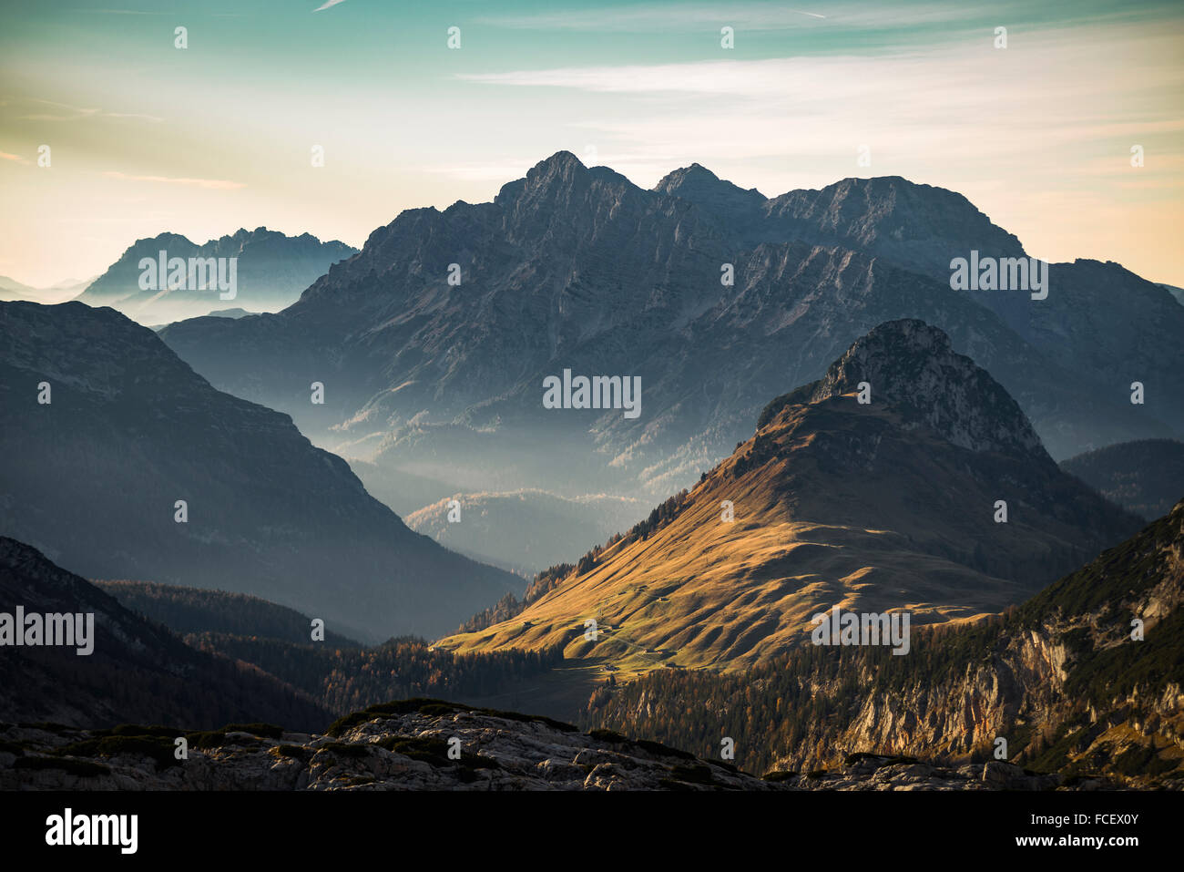 Late autumn sunset with warm sunlight on alpine pastures and the Austrian mountain cliffs and peaks of Loferer Steinberge Stock Photo