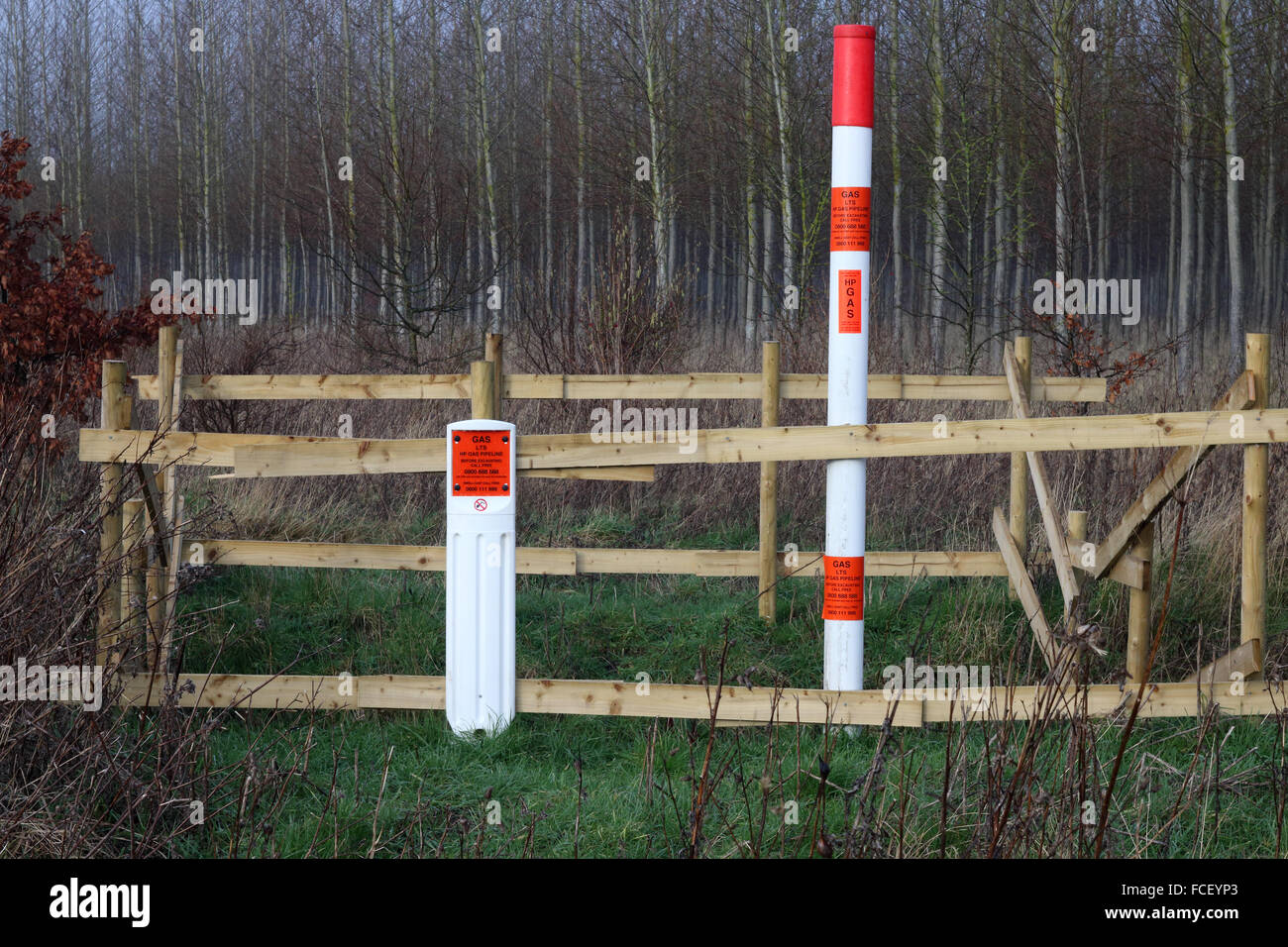 Warning sign and fence alerting people to the fact that there is a high pressure gas pipe buried under the ground Stock Photo