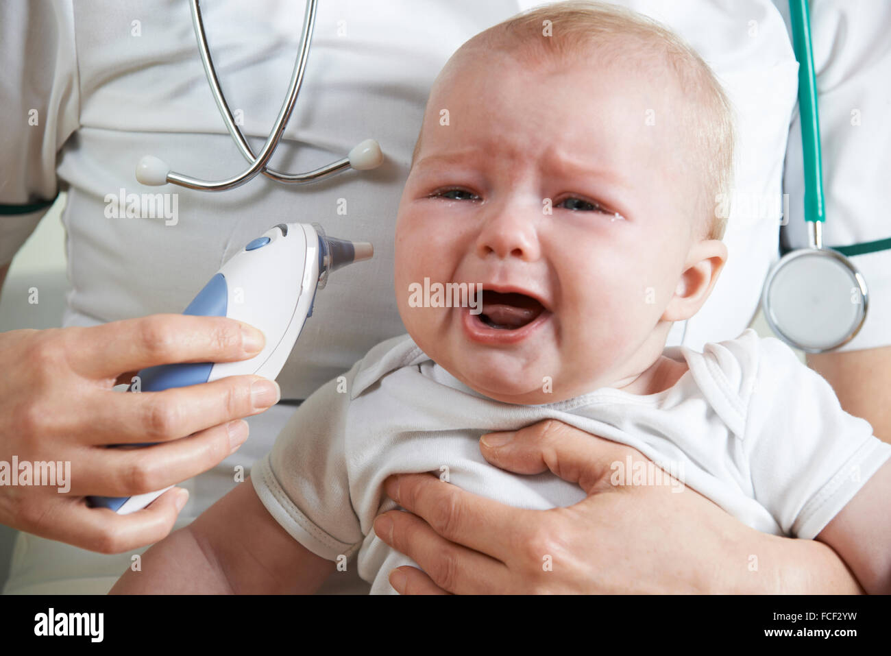 Nurse Taking Crying Baby's Temperature With Digital Thermometer Stock