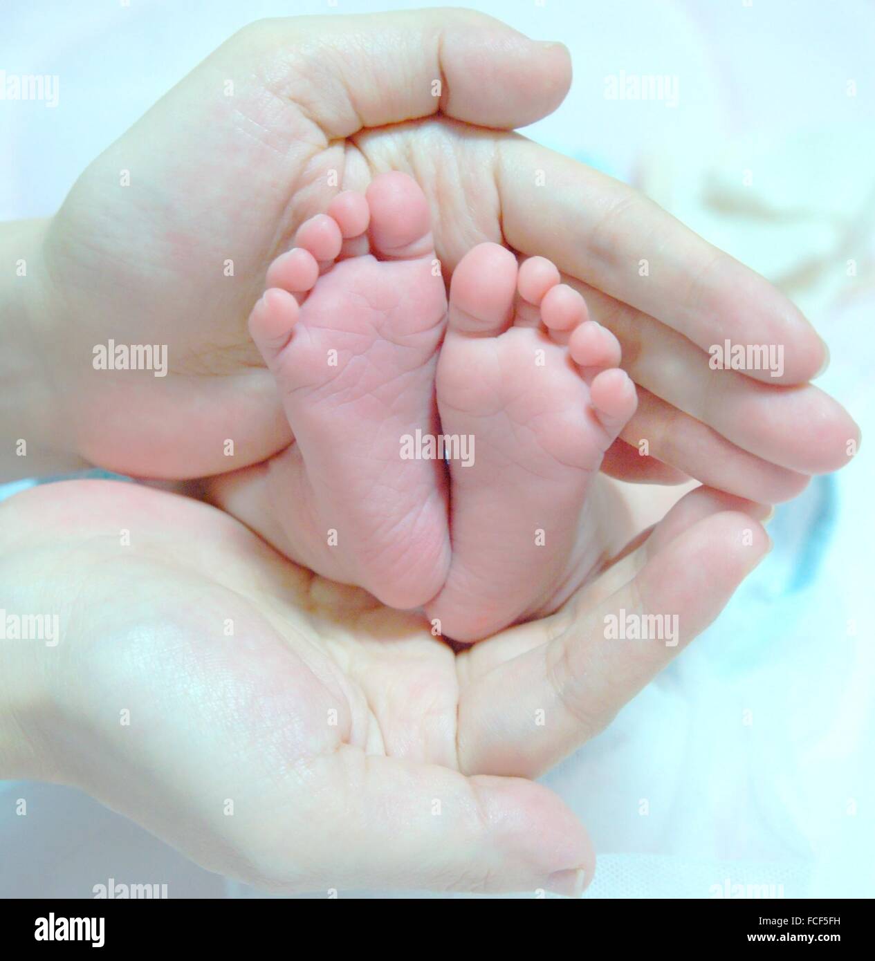 Baby hands holding feet hires stock photography and images Alamy