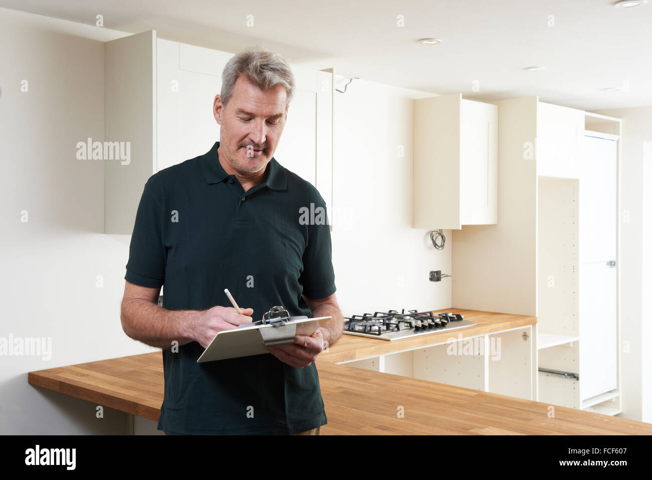 Carpenter Installing Luxury Fitted Kitchen Stock Photo Alamy