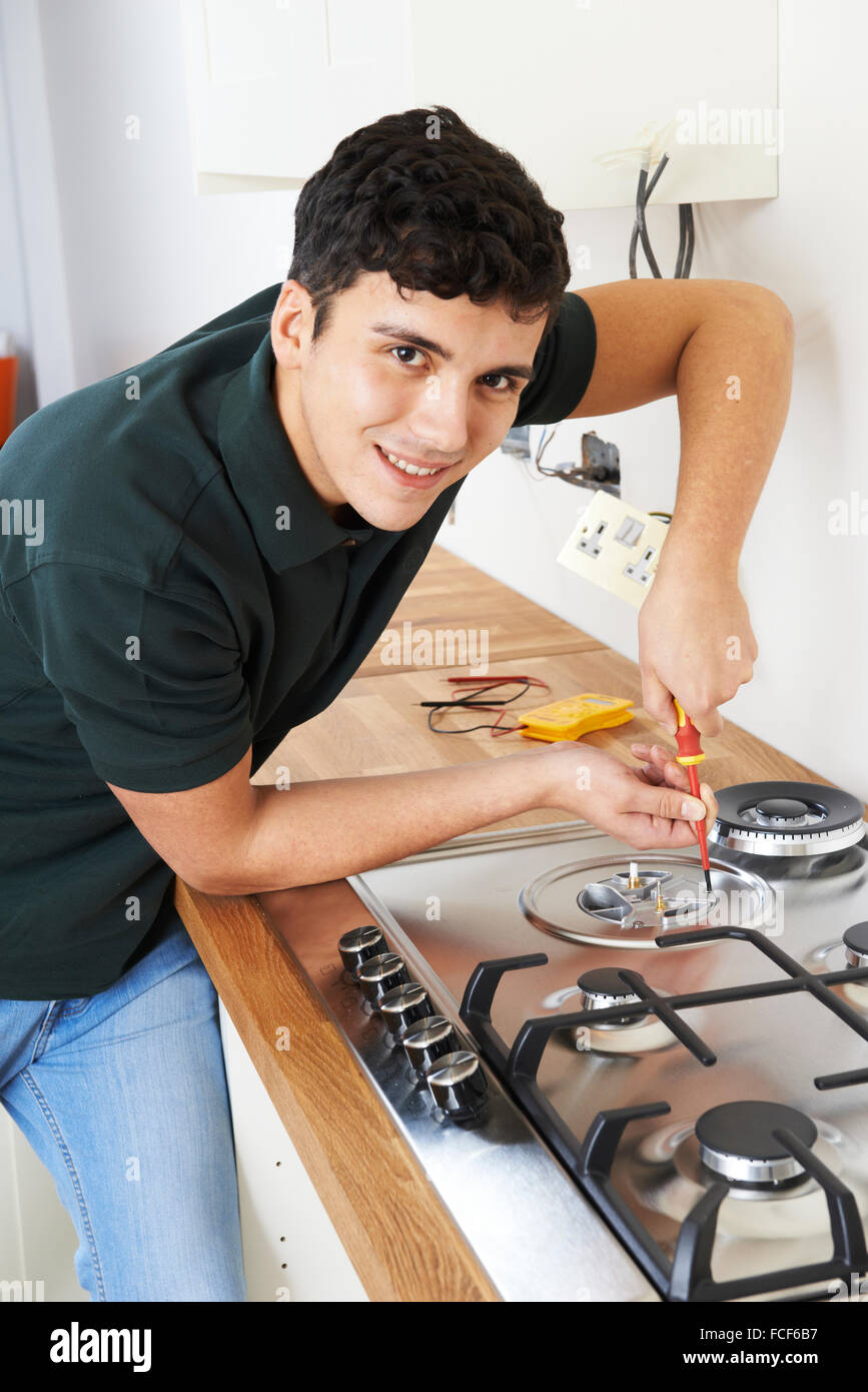 Workman Installing Gas Cooker In New Kitchen Stock Photo