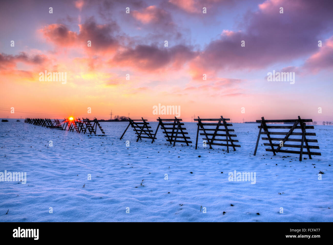 Wooden snow blizzard shields on the winter field at sunset - HDR Image Stock Photo