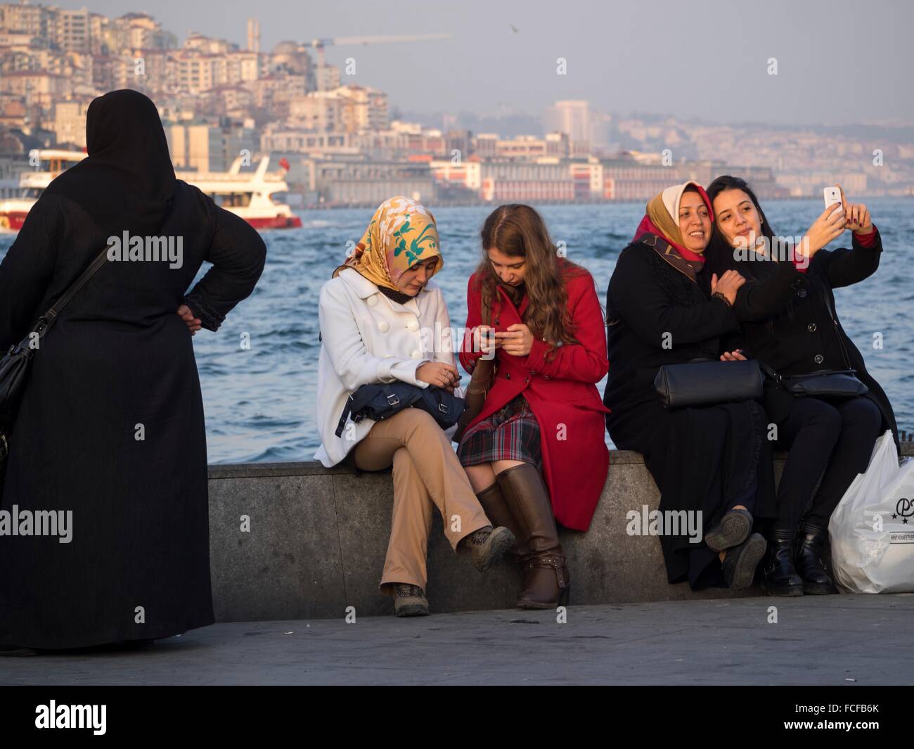 Women using cell phone at waterfront in Istanbul, Turkey Stock Photo