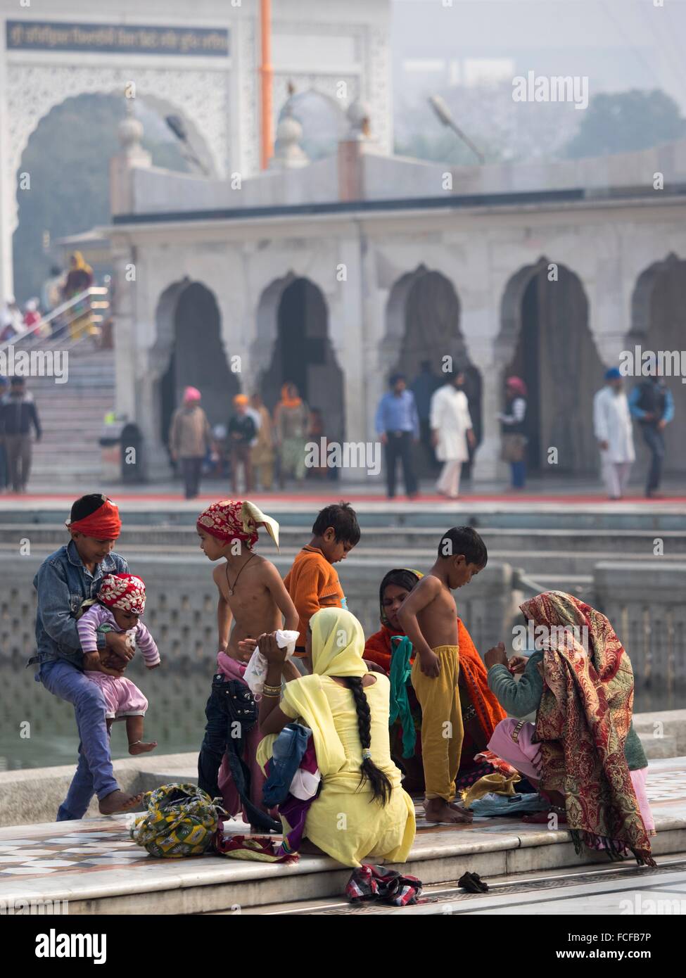 Women wiping her son after bath at Gurudwara Bangla Sahib shrine, New
