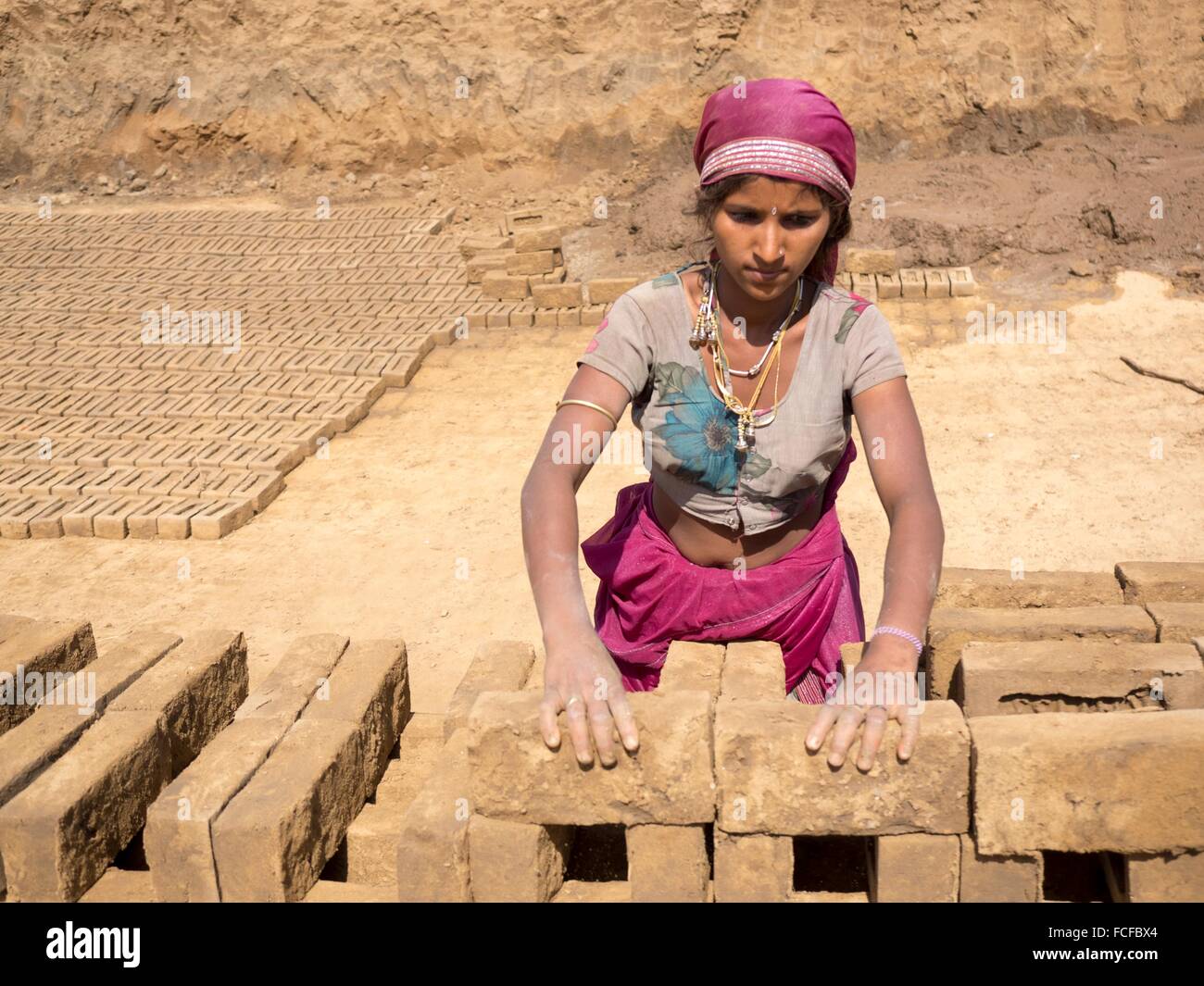Woman with mud bricks in Chhatrasagar, Rajasthan, India Stock Photo