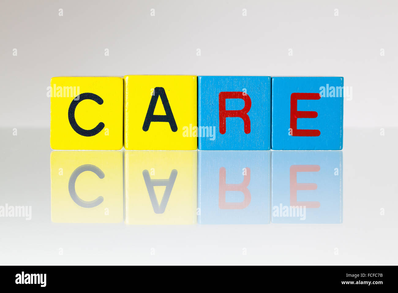 Care - an inscription from children's wooden blocks Stock Photo