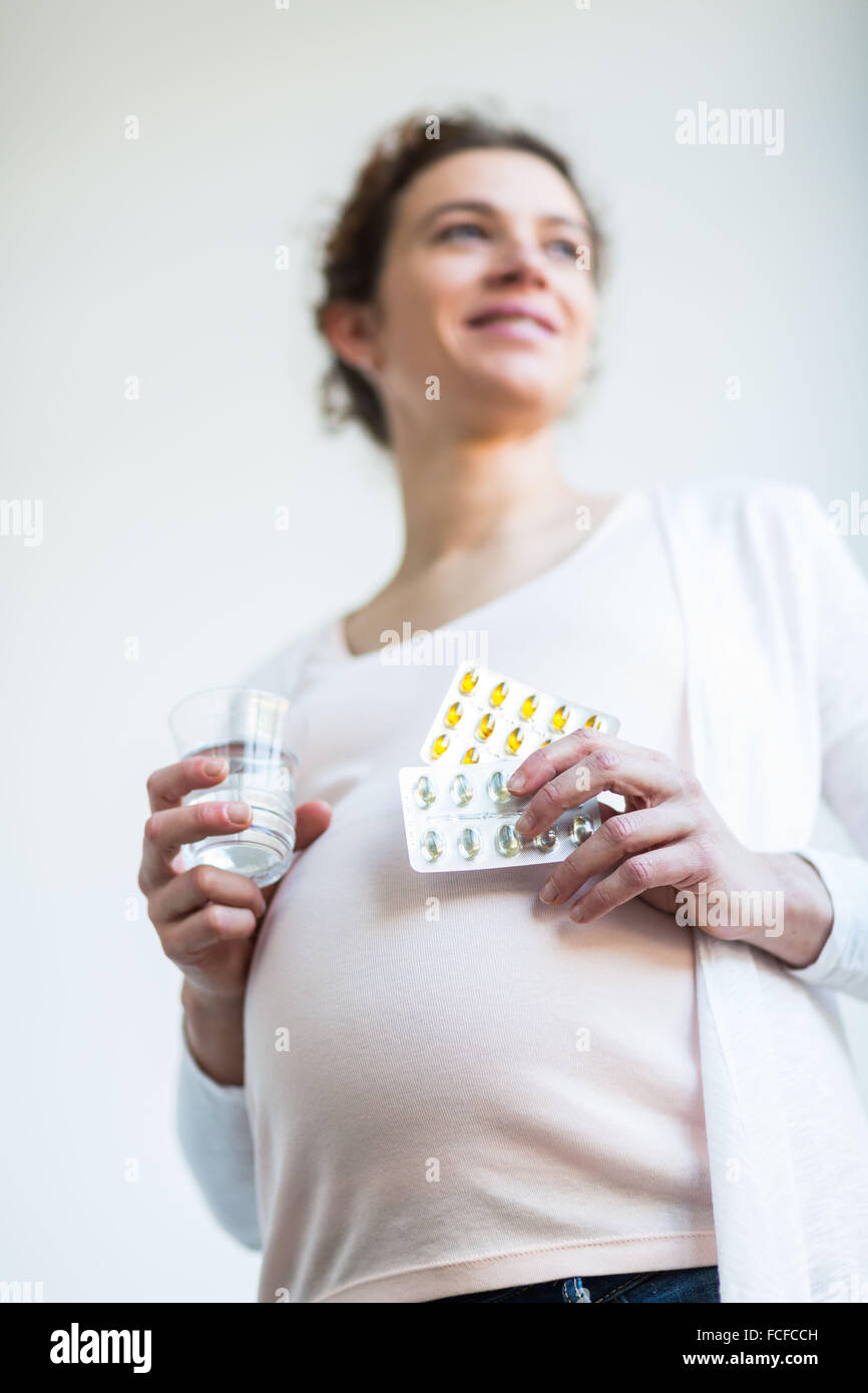 Pregnant woman taking gelatine capsules Stock Photo Alamy