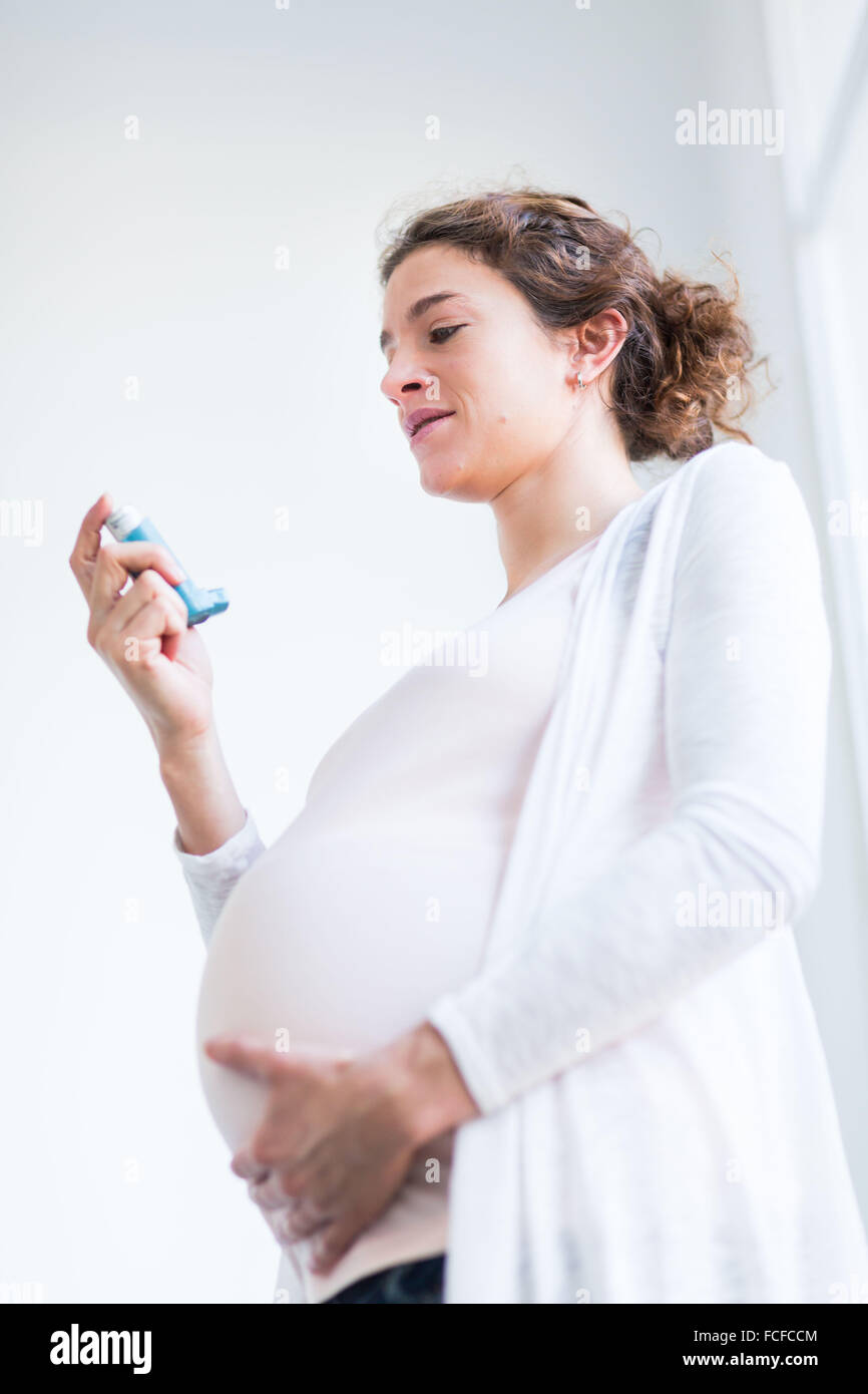 Pregnant woman using an asthma inhaler Stock Photo Alamy