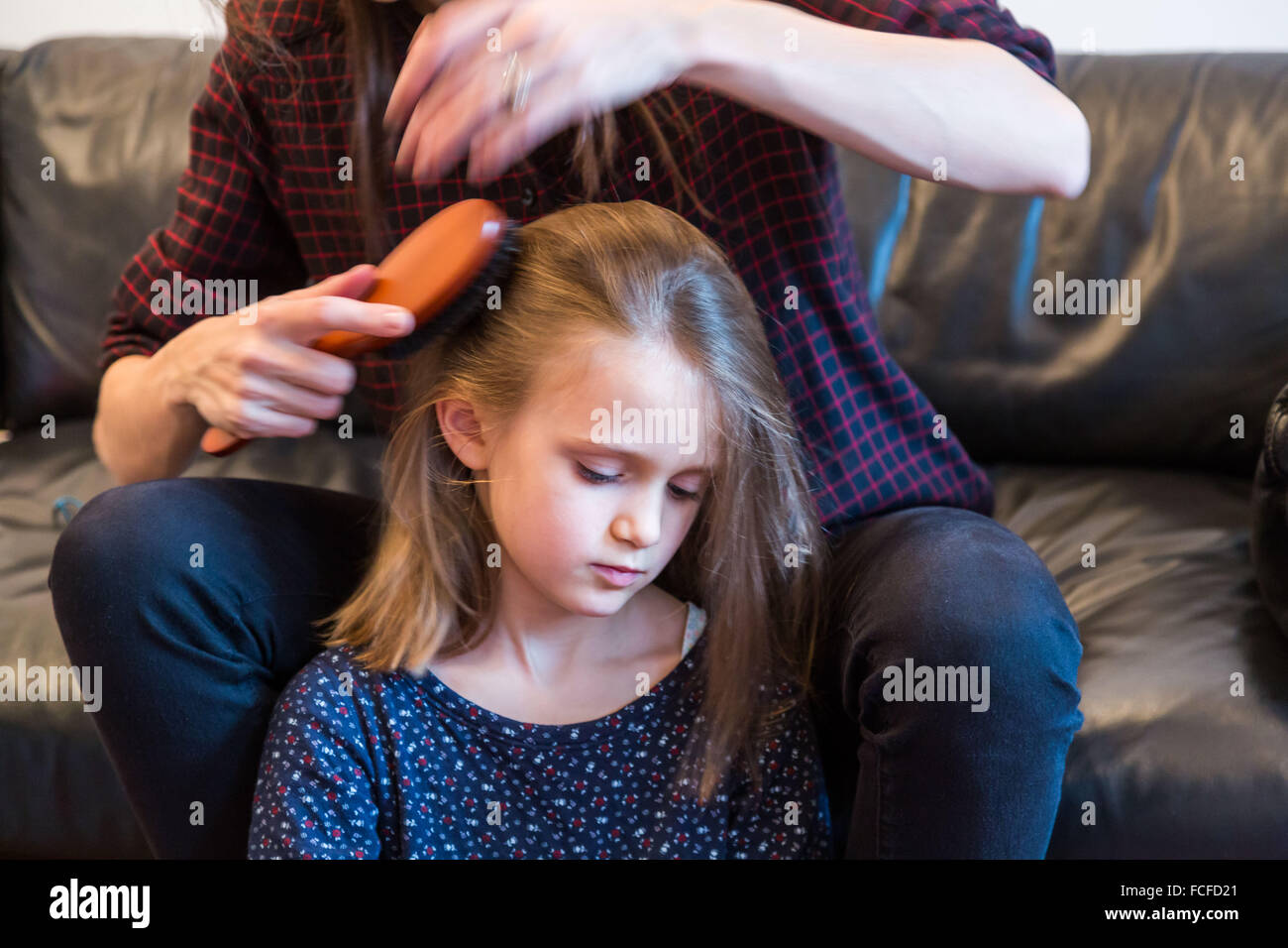 Mother combing her 6 year-old daughter's hair. Stock Photo