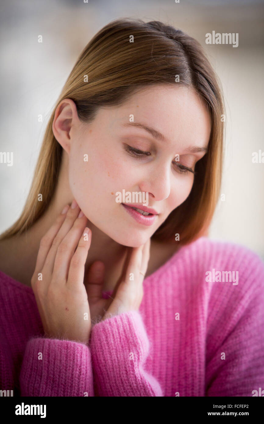 Woman stroking her throat Stock Photo - Alamy