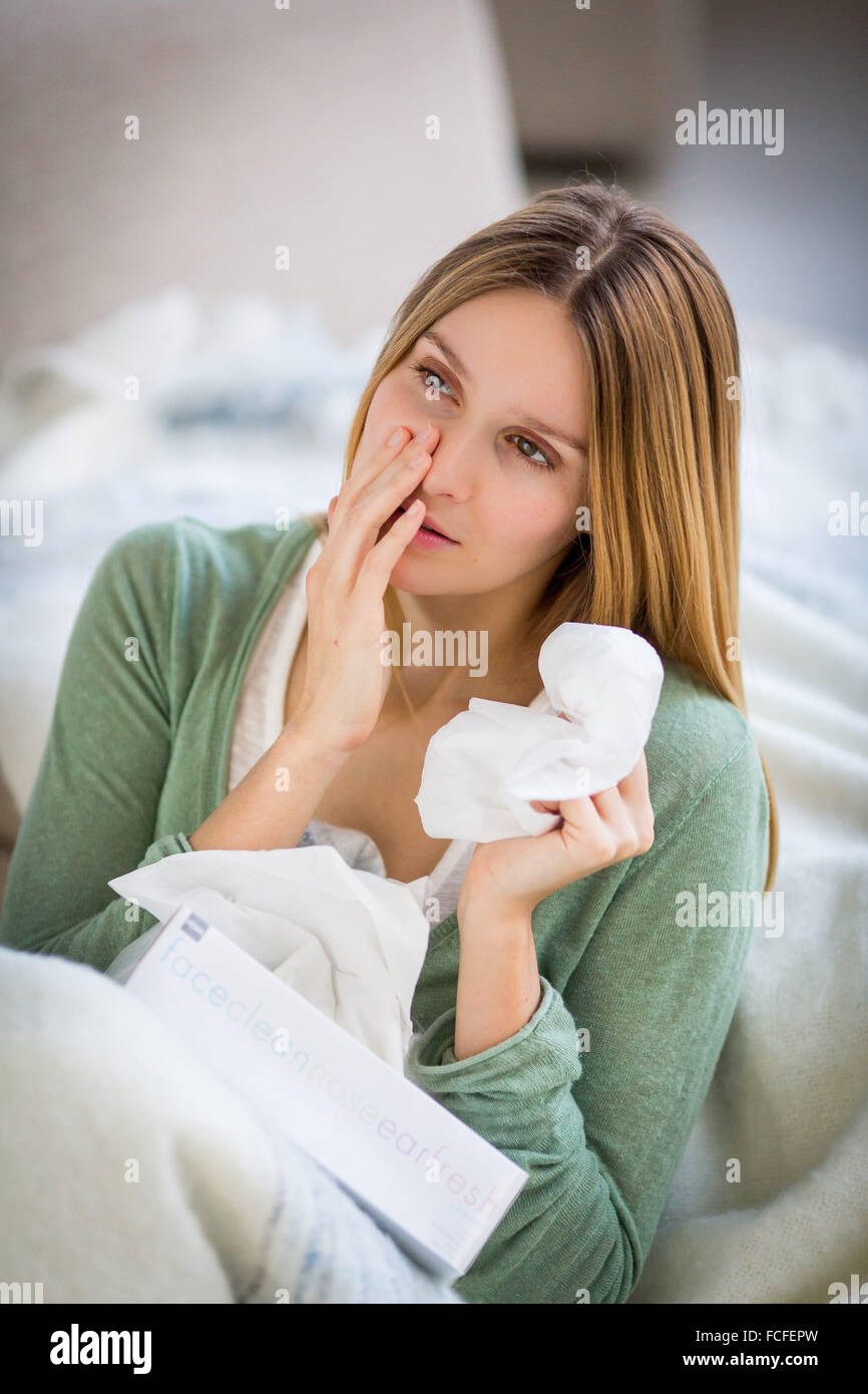 Woman with a cold using tissue. Stock Photo
