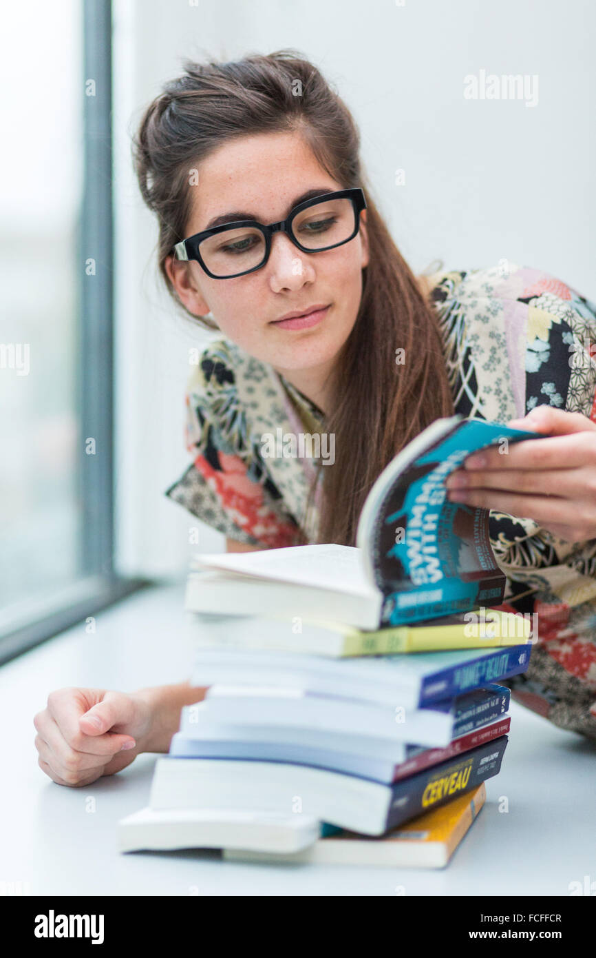 Young woman with pile of books Stock Photo - Alamy