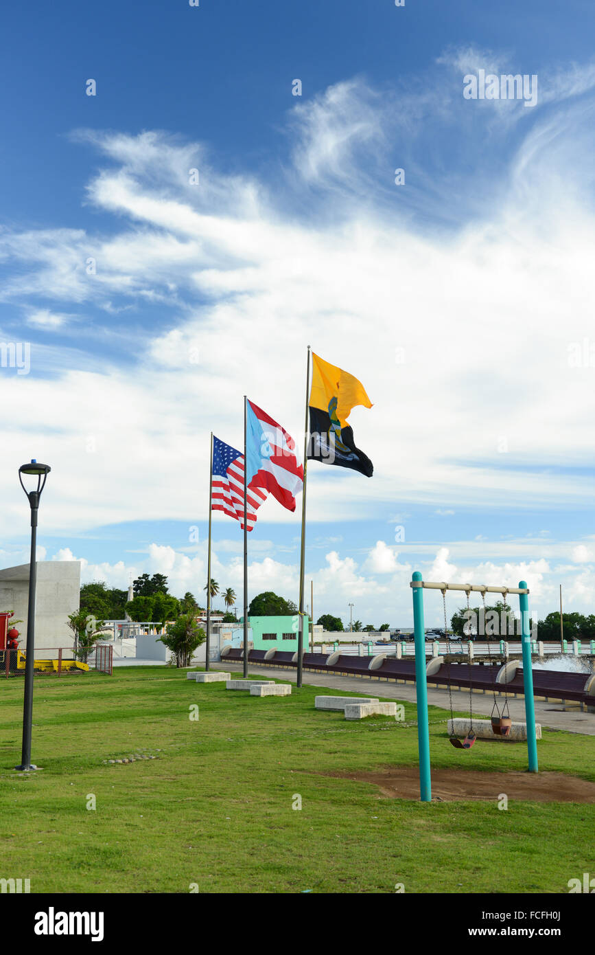 USA, Puerto Rico and Arroyo flags waving at the boardwalk. Arroyo, Puerto Rico. Caribbean Island. USA territory. Stock Photo