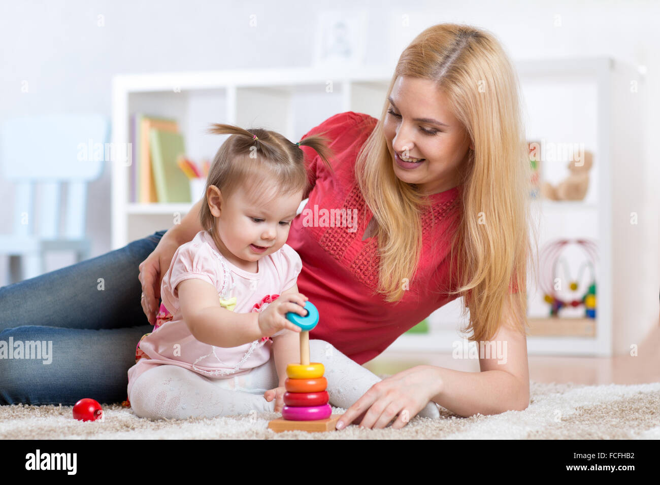 Mother with her child playing with wooden blocks at home Stock Photo ...