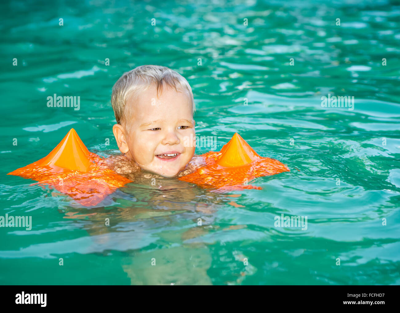 Baby with armbands in swimming pool Stock Photo Alamy