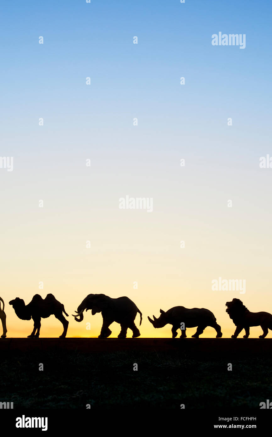 Toy model animals silhouette against a dawn sky Stock Photo