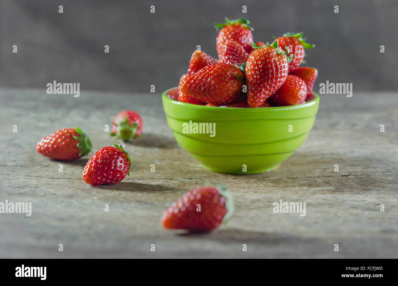 Green bowl filled with fresh ripe red strawberries Stock Photo