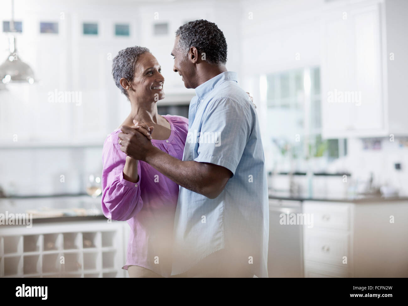An affectionate mature African American couple, with their arms around each other dancing. Stock Photo