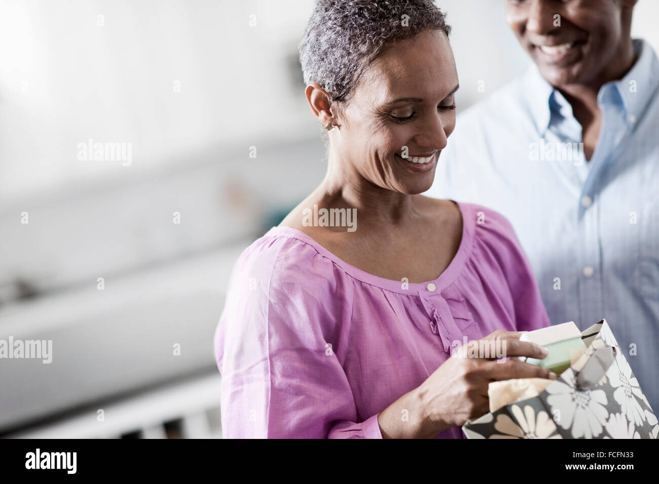 An affectionate mature African American couple, with their arms around each other in their home. Stock Photo