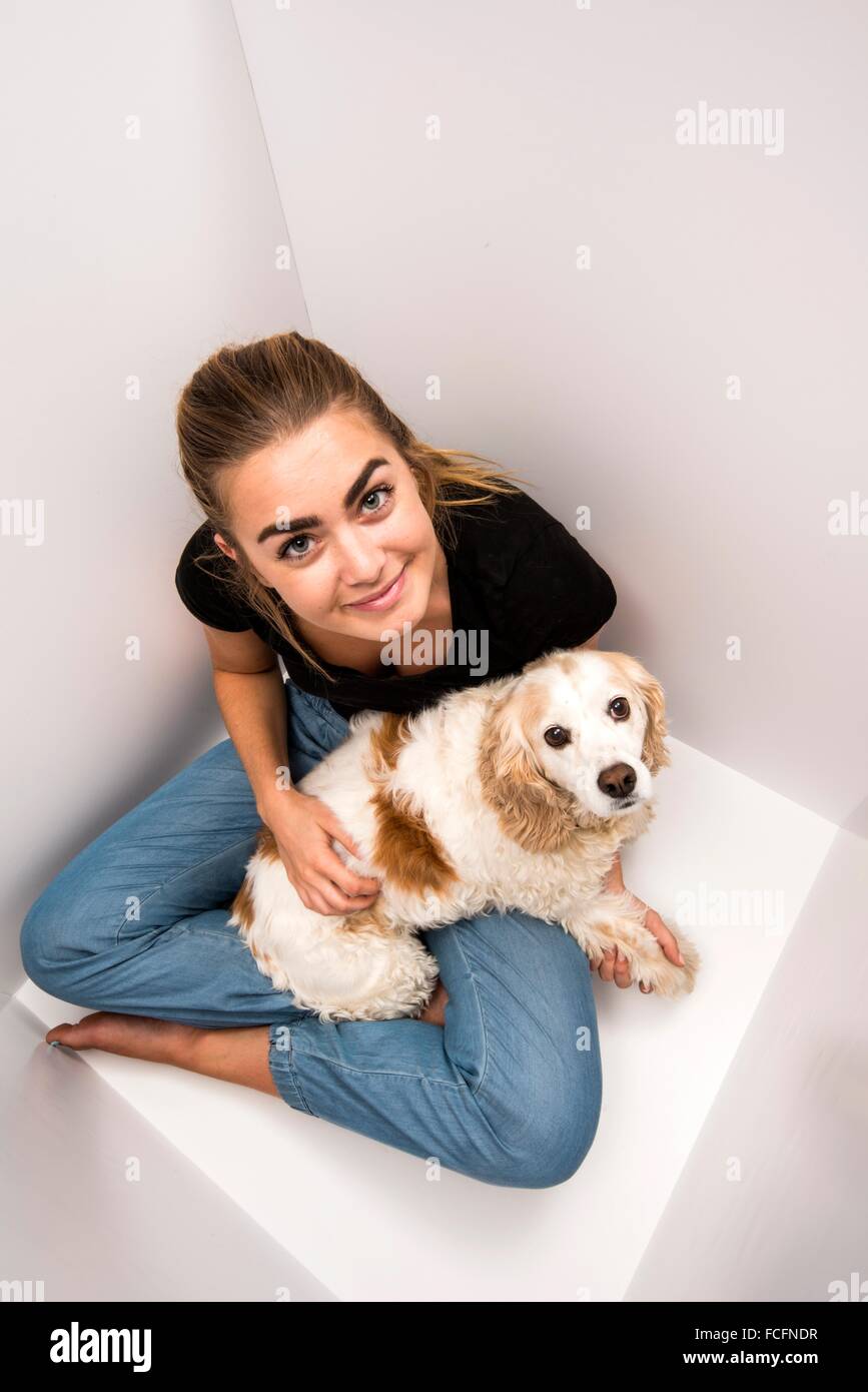 a 19 year old woman with her cocker spaniel in a white box. Stock Photo