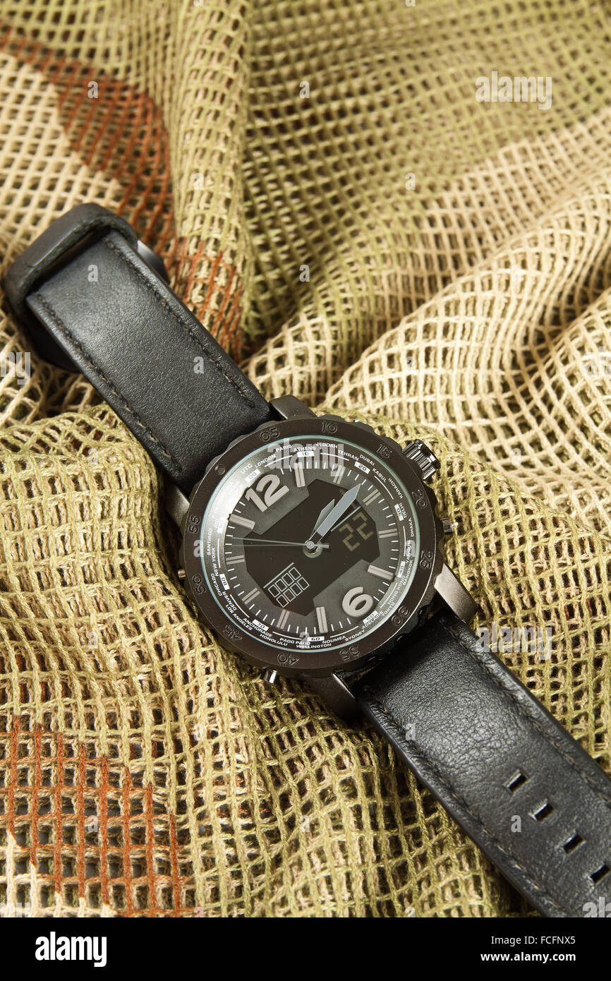 Men's Watch Chronograph on camouflage netting Stock Photo