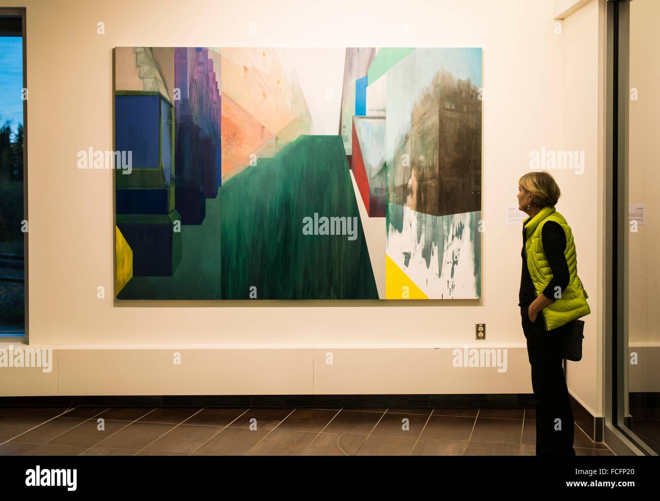 A woman, 65, looks at a painting in the Esker Foundation gallery in