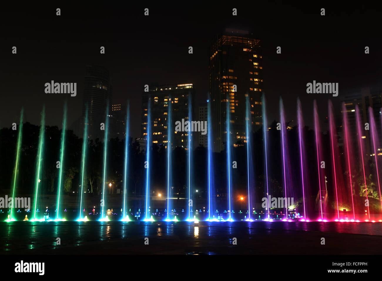 Illuminated fountain at night in modern city skyline, Kuala Lumpur ...
