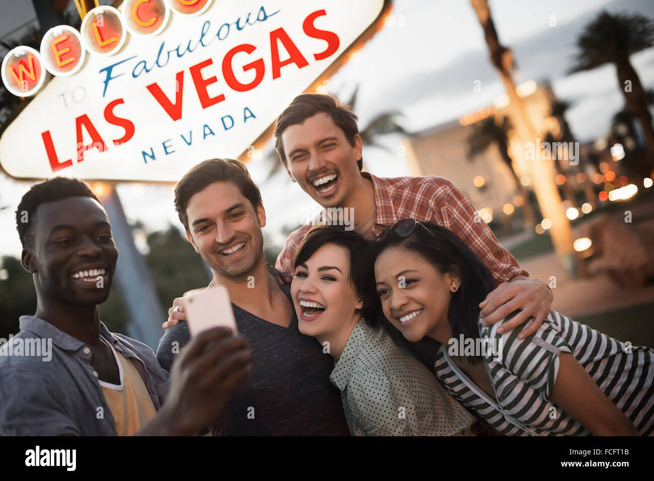 A group of five friends, men and women posing under the Las Vegas sign. Stock Photo