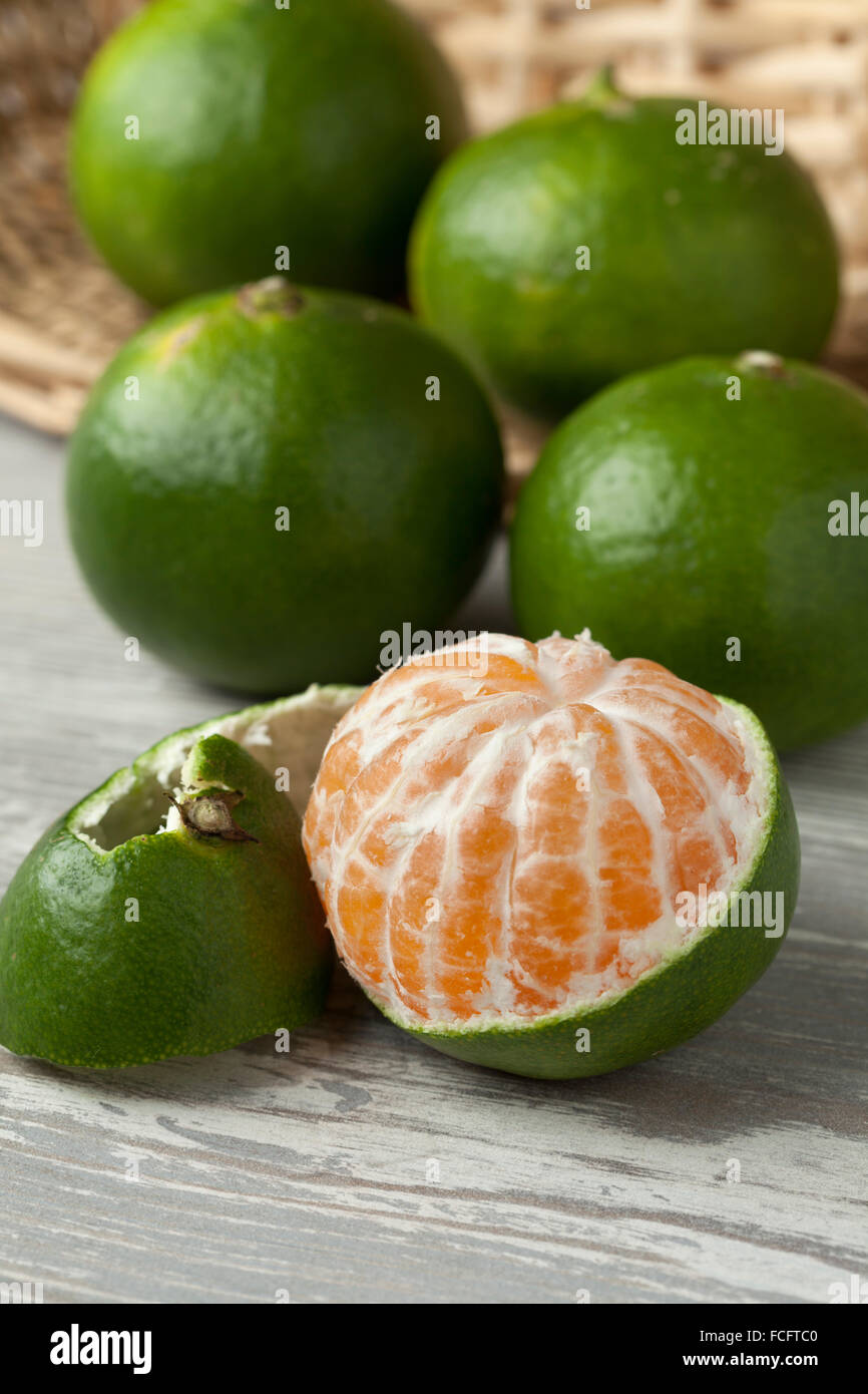 Green and peeled satsuma fruit Stock Photo