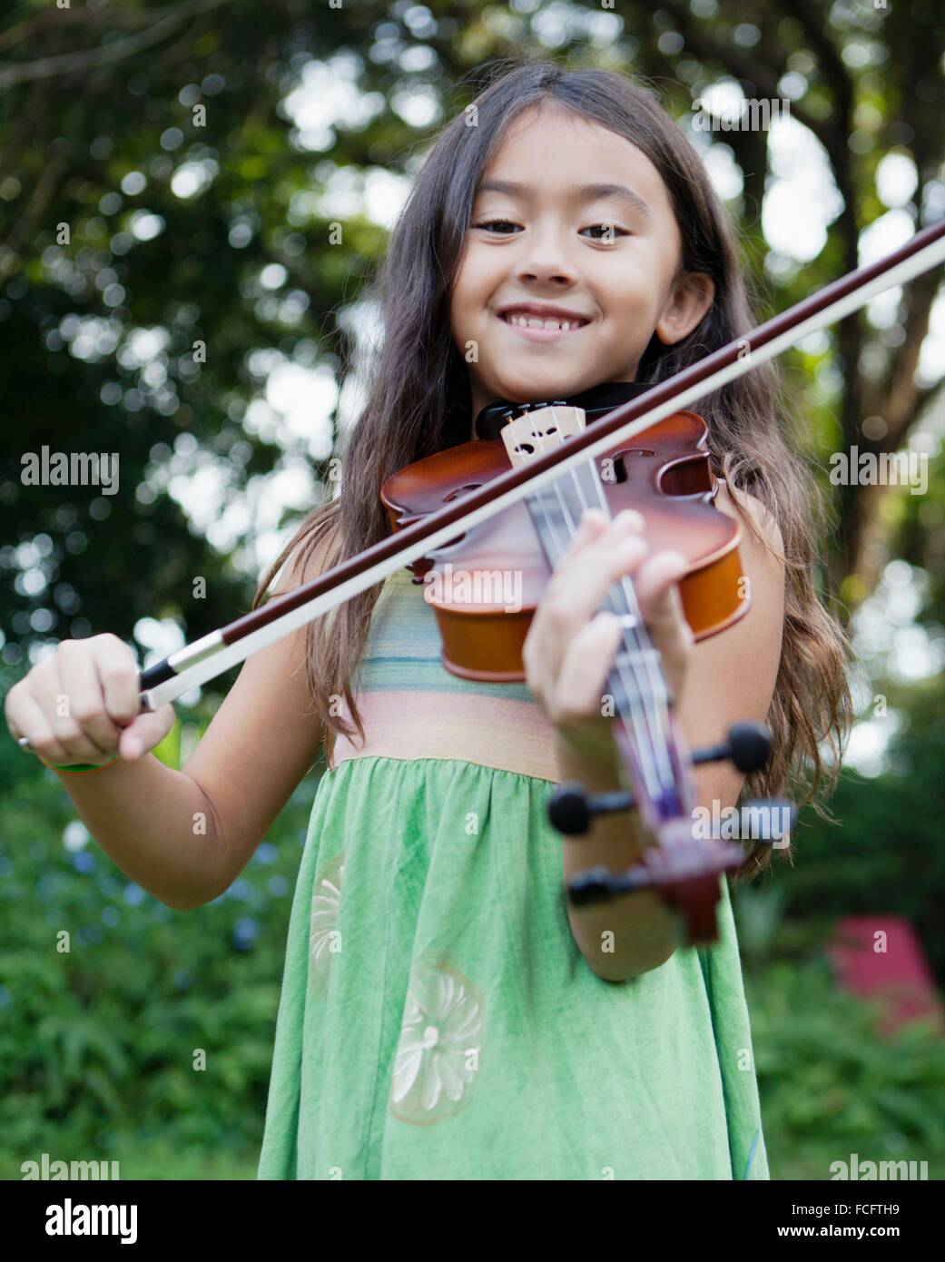 A young girl playing the violin outside Stock Photo - Alamy