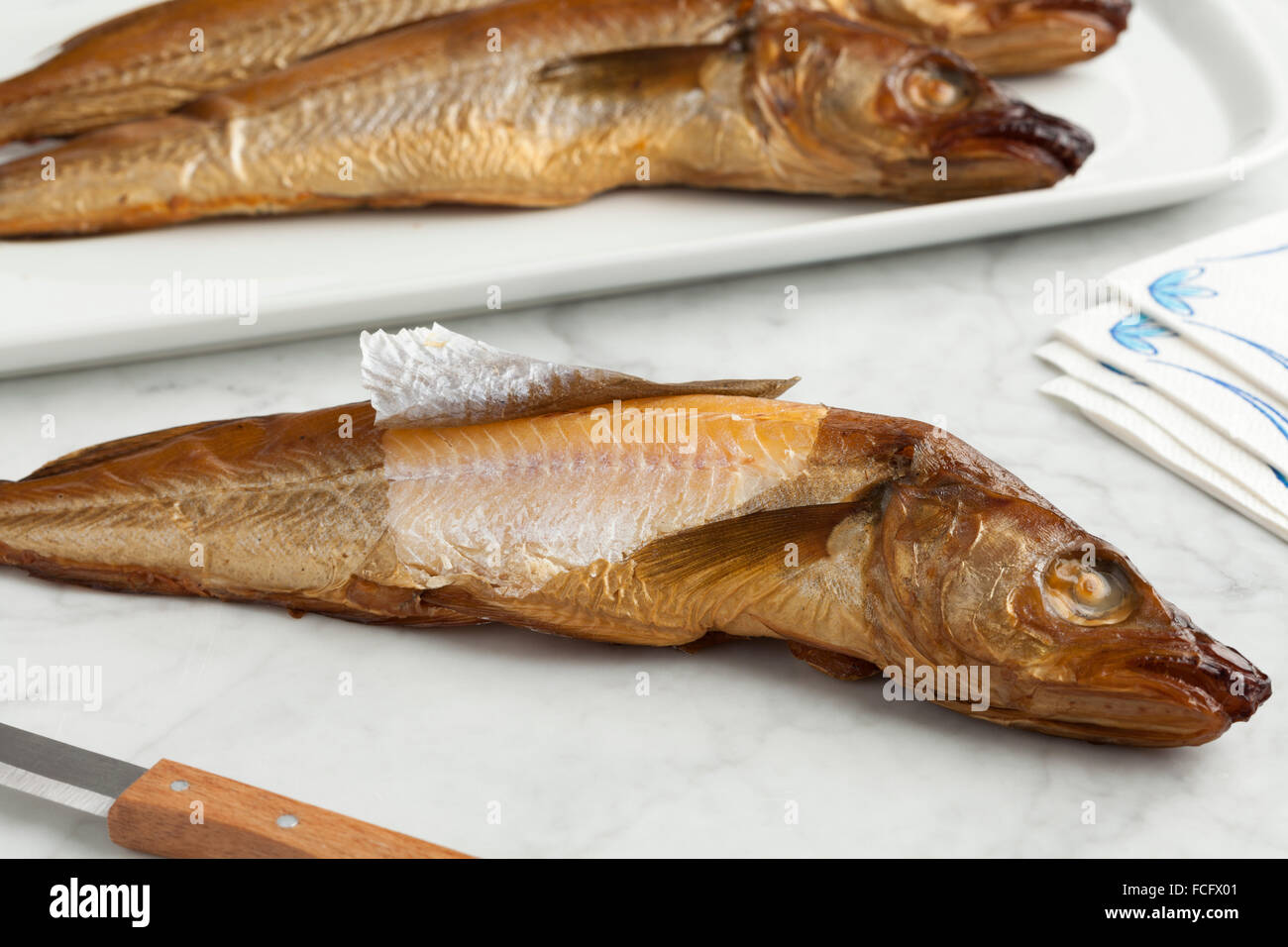 Fresh smoked whiting fish on the table Stock Photo