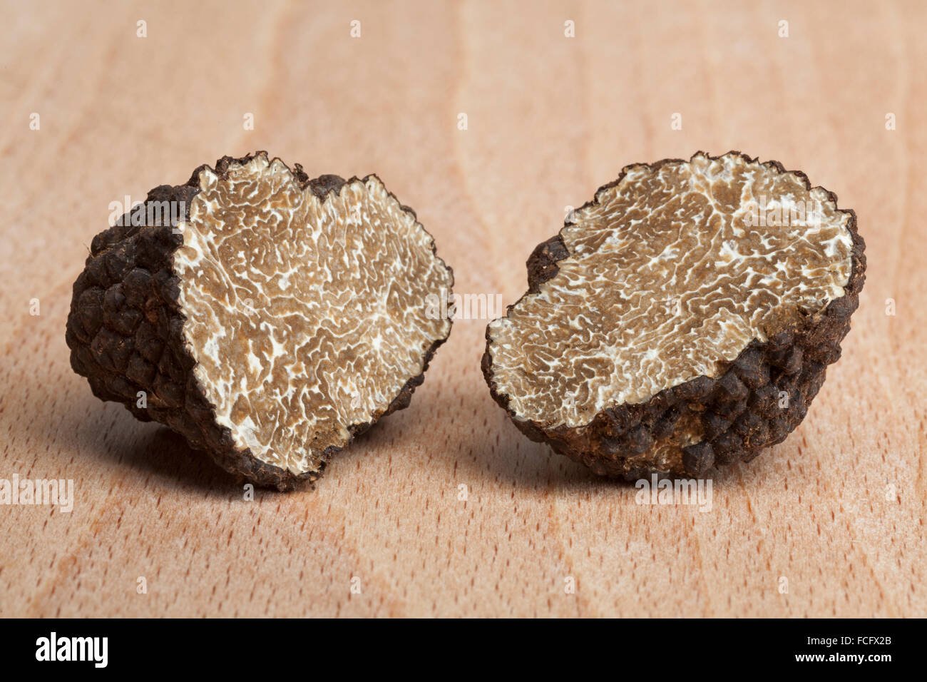 Two fresh half black truffles on wood Stock Photo