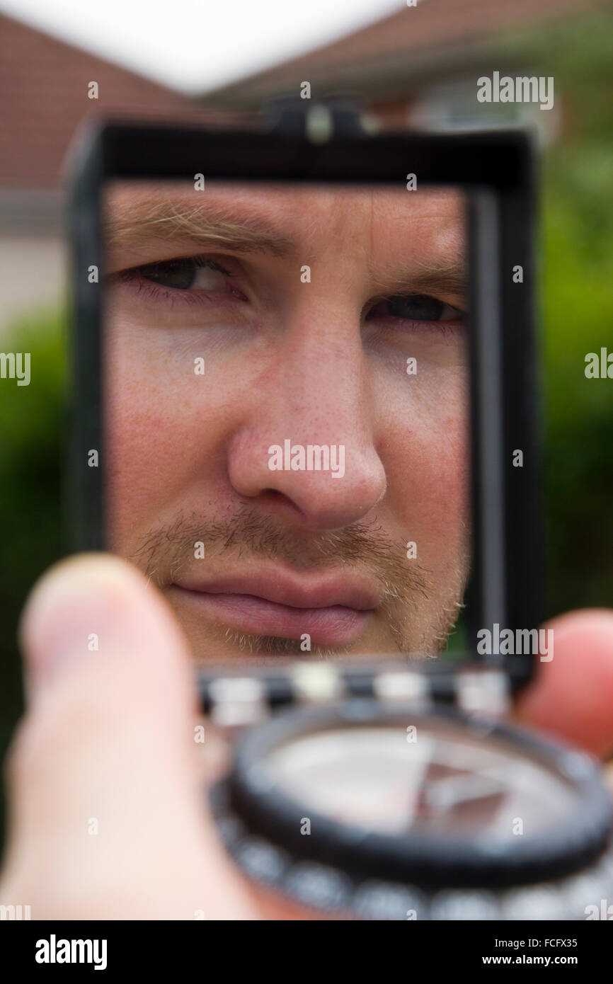 Portrait of a man getting a bearing from a compass Stock Photo