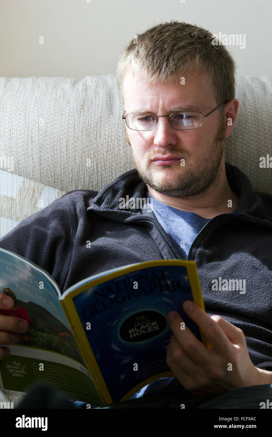 Man reading a magazine at home Stock Photo