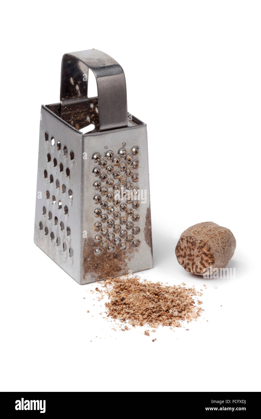 Ground nutmeg kernel and grater on white background Stock Photo