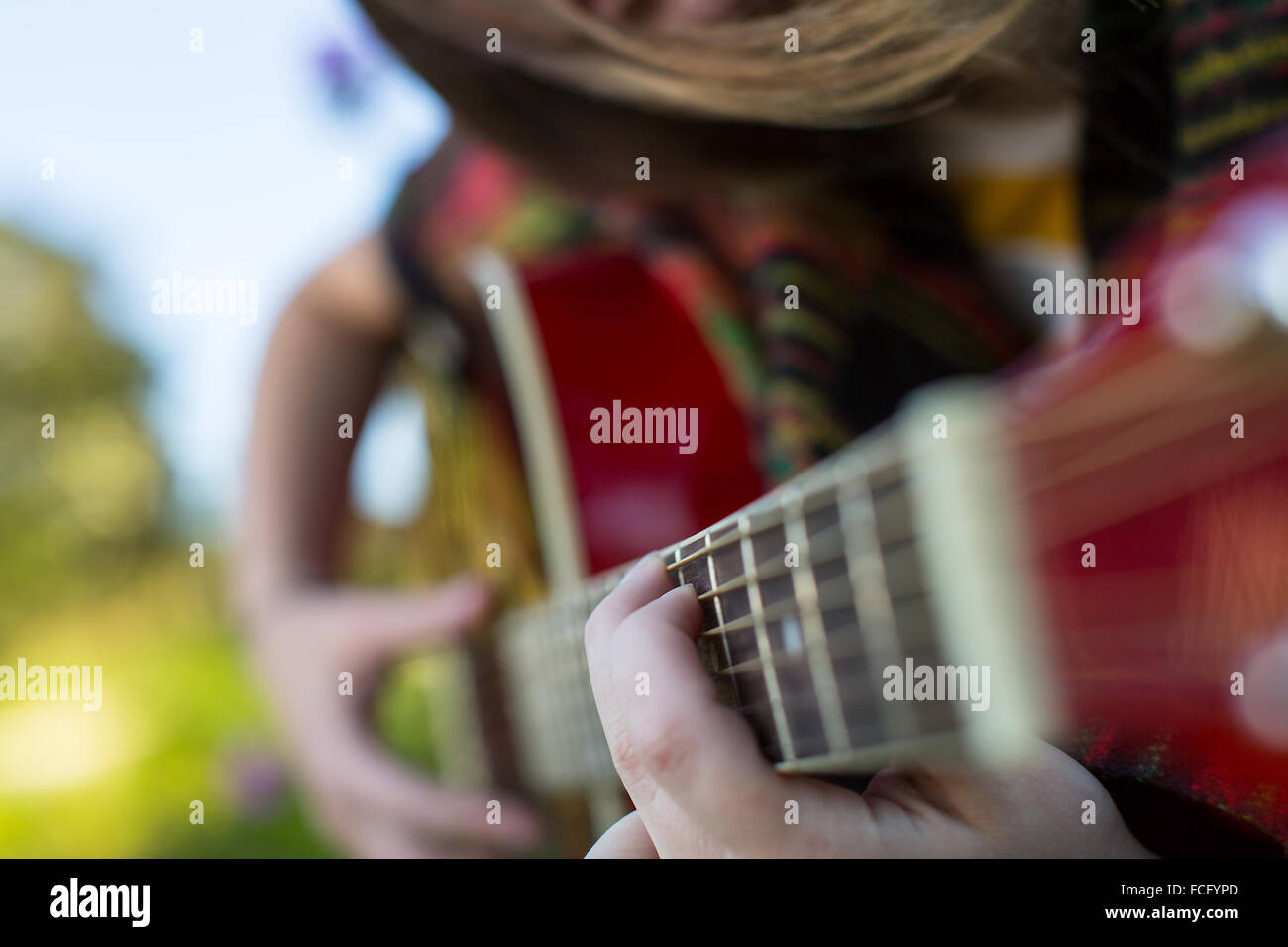 Fingers on the strings close up, girl playing acoustic guitar Stock