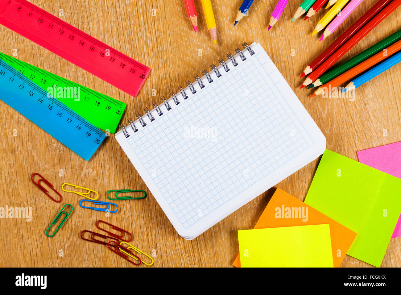 Colored pencils and notepad on wooden table Stock Photo - Alamy